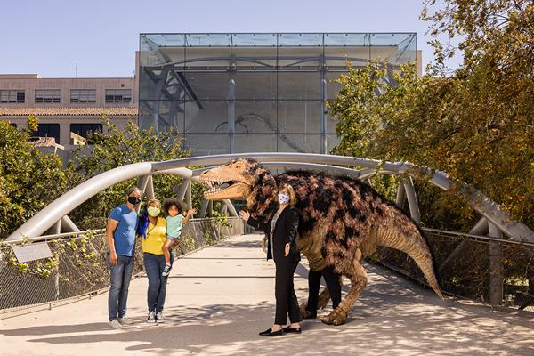 Dr. Lori Bettison-Varga, President and Director of the Natural History Museums of Los Angeles County (NHMLAC), and Hunter the T-Rex puppet welcome back visitors to the Natural History Museum of Los Angeles County (NHM). Exposition Park, Los Angeles, CA. April 1, 2021. Photography by Gina Cholick. Courtesy of the Natural History Museums of Los Angeles County (NHMLAC).