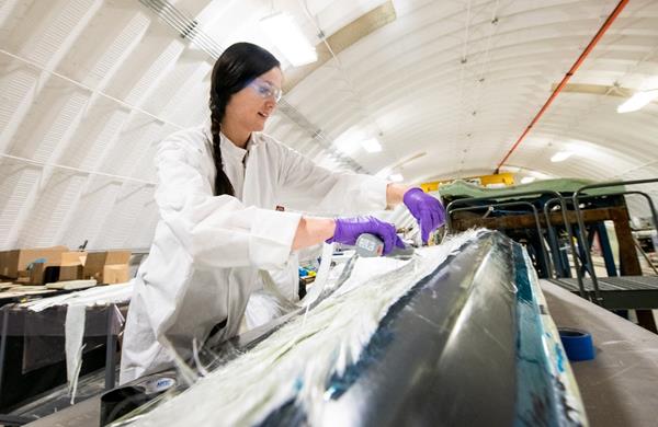 NREL researcher Robynne Murray works on a thermoplastic composite turbine blade at the Composites Manufacturing Education and Technology Facility at NREL’s Flatirons Campus. Photo by Dennis Schroeder 