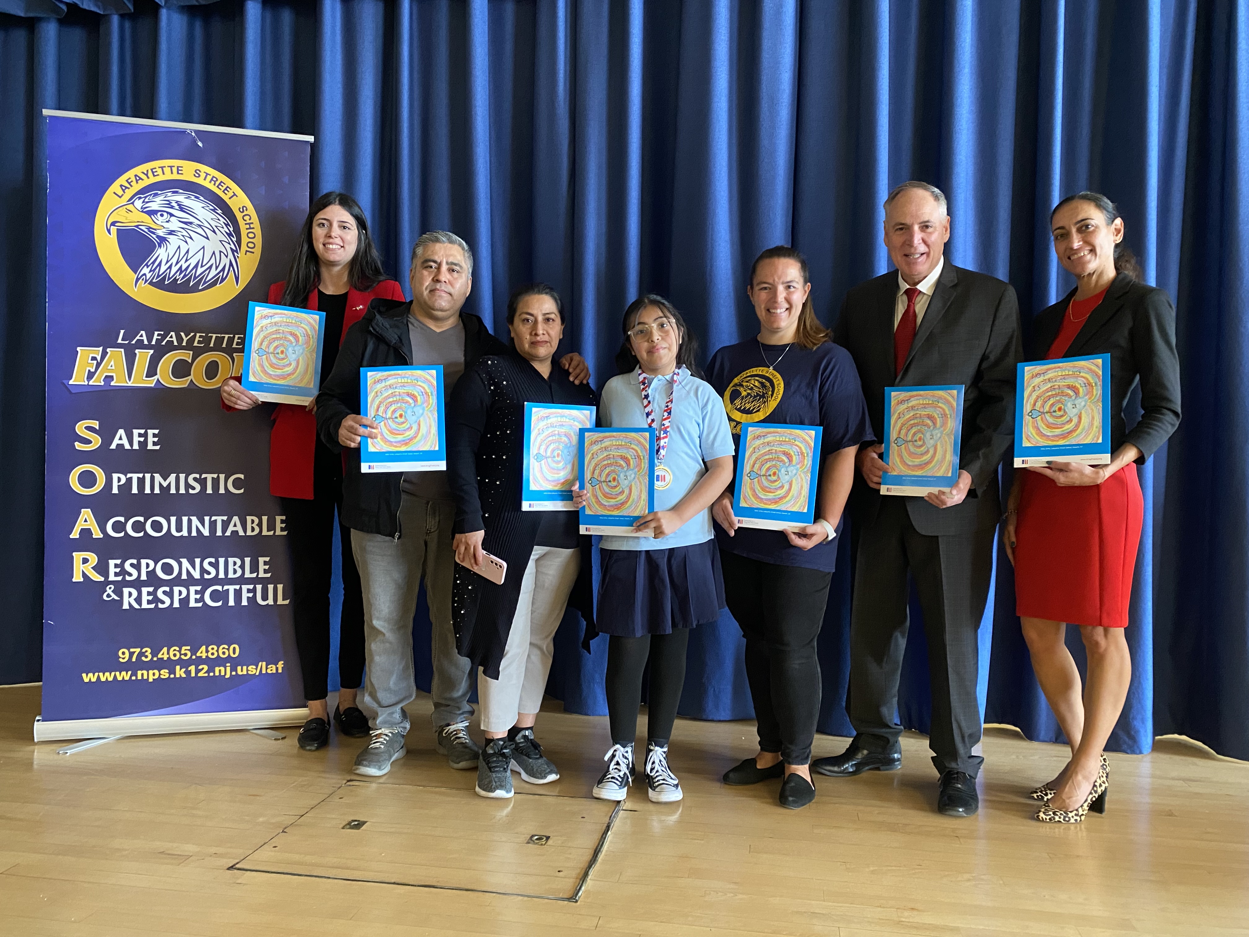 Emily Ortiz of Lafayette Street School in Newark was one of two grand prize winners of the Partnership for a Drug-Free New Jersey's 2023-24 Fourth Grade Folder contest. Her winning artwork is displayed on 30,000 folders distributed to fourth-grade classes throughout the state. Adam Idrovo of Good Shepherd Academy in Nutley was also selected as a grand prize winner. From left, Lafayette Street School Vice Principal Eva Almeida, Emily's father Tamar Ortiz, her mother Maribel Ortiz, Emily, art teacher Paula Cox, PDFNJ Executive Director Angelo Valente and Principal Diane Pereira.