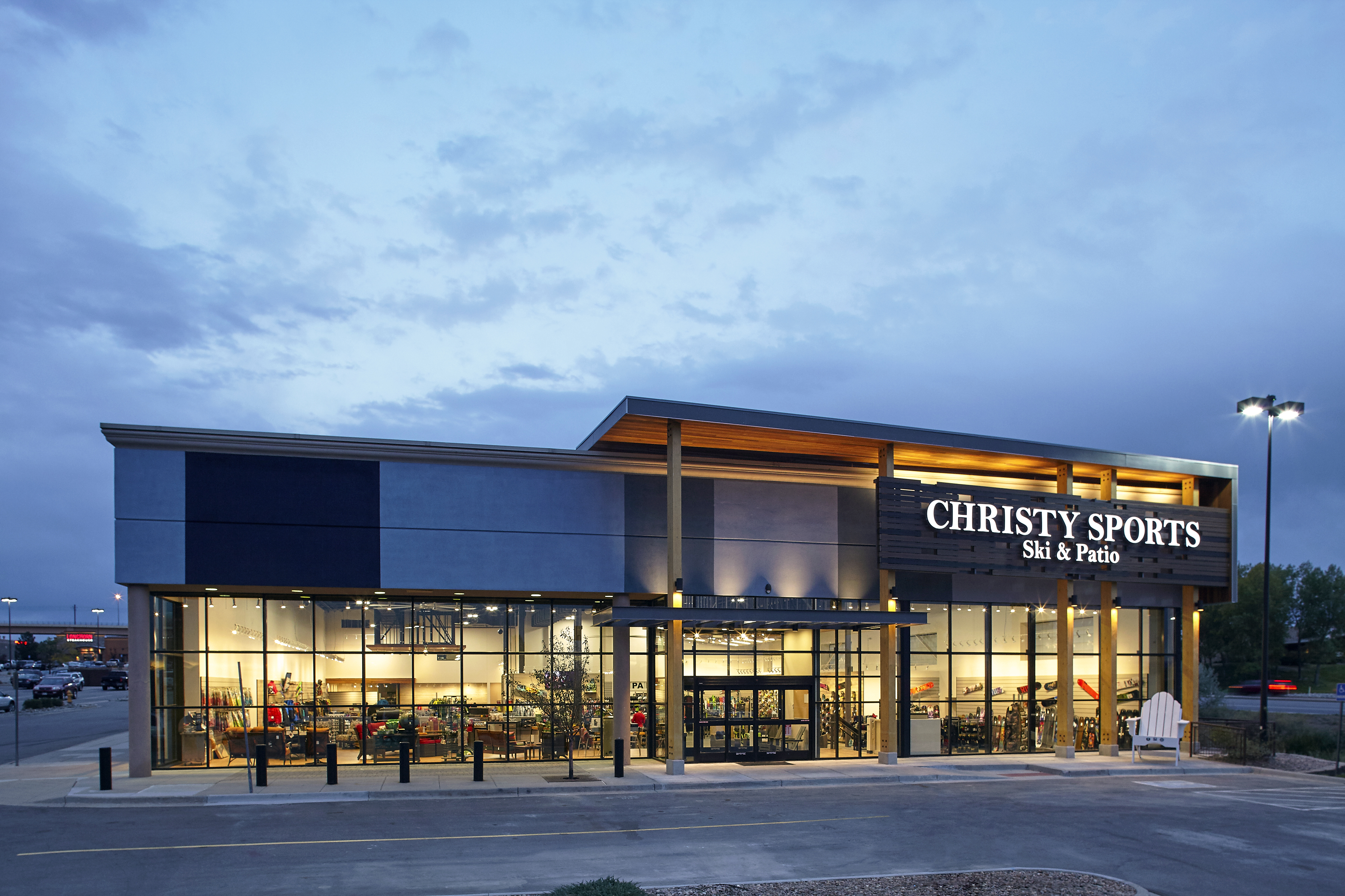 Exterior of Christy Sports store location glowing at dusk