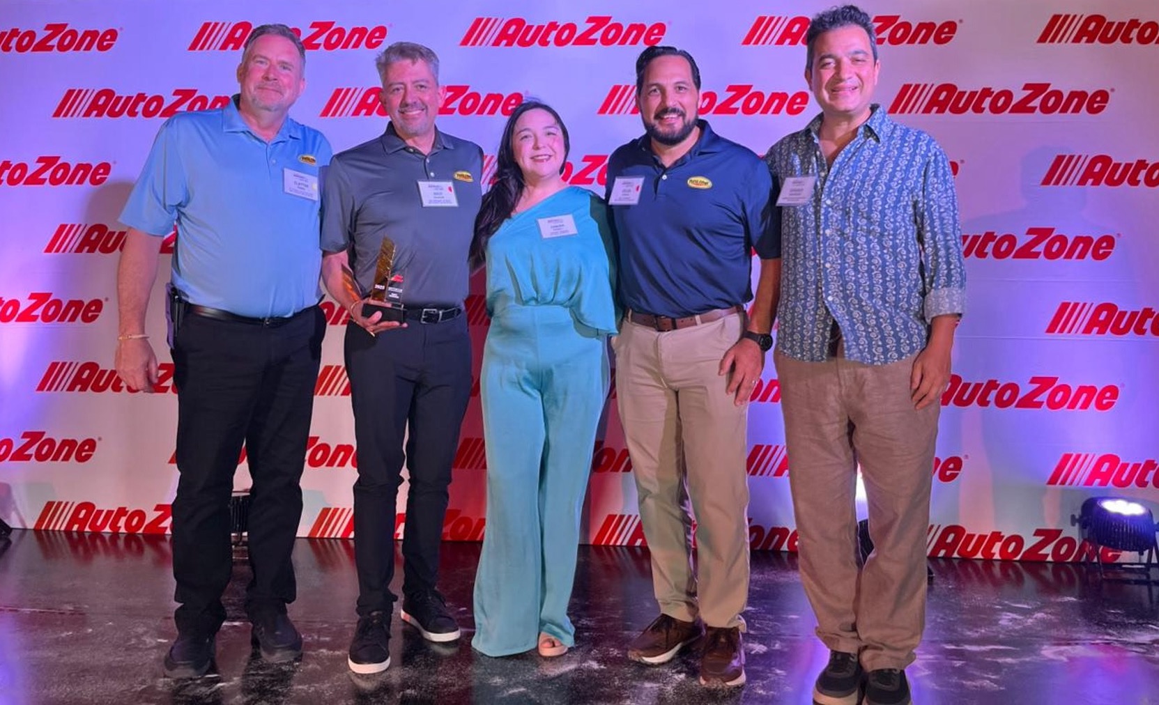 Representatives of Rislone standing on a stage receiving an award from representatives of AutoZone Mexico