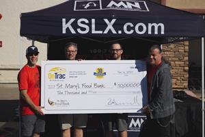 OnTrac presents check to St. Mary's Food Bank at KSLX event.