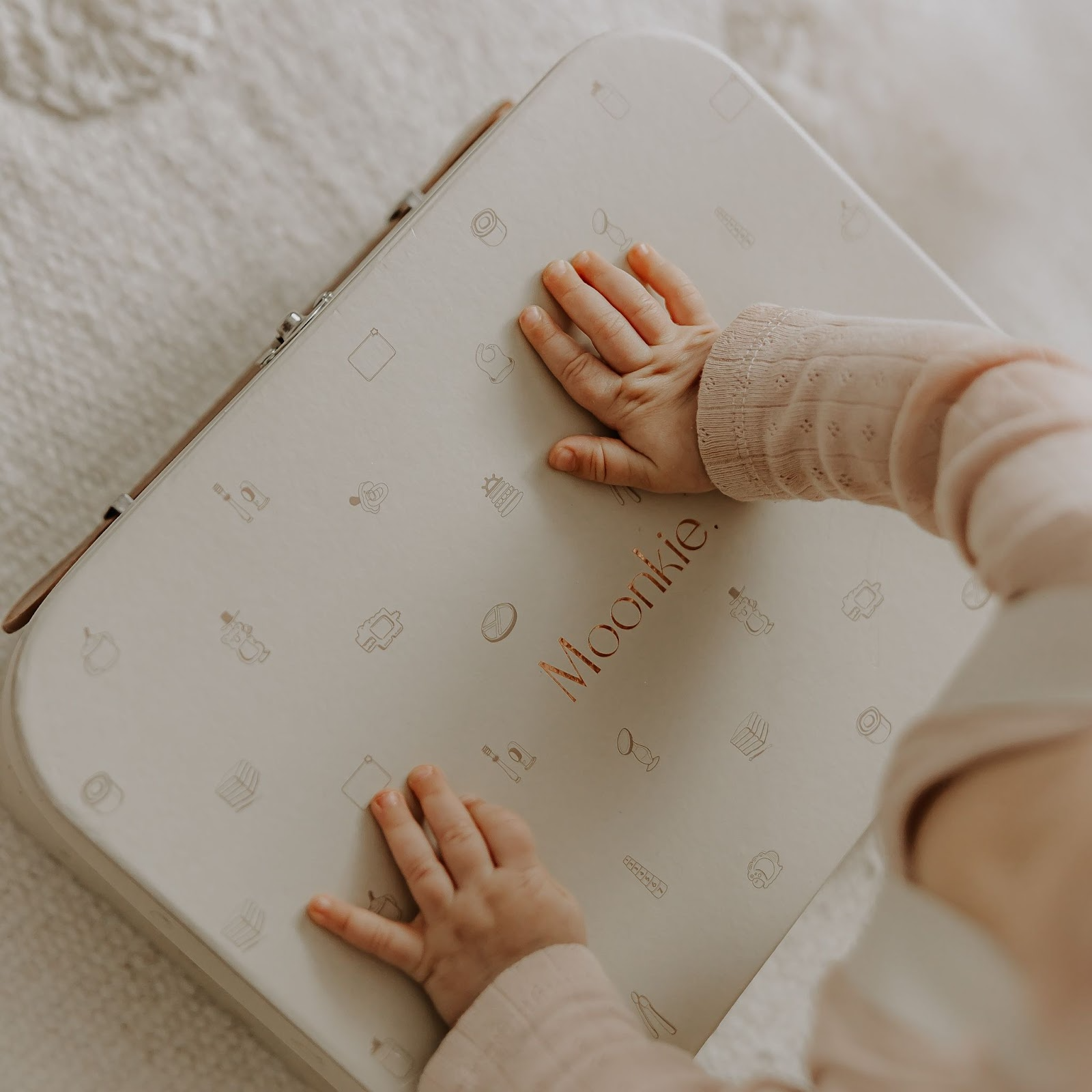 A baby with her parents holding a gift box - Image | Moonkie
