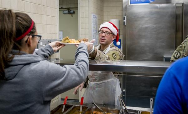 U.S. Army Lt. Col. Matthew Kopetski, Area Support Group – Kuwait command judge advocate, serves food to soldiers and civilians during the Christmas meal at Camp Arifjan, Kuwait, Dec. 25, 2018. It is a military tradition for officers and senior enlisted members to serve food during the holidays. (U.S. Army photo by Staff Sgt. Andrew Carroll) 