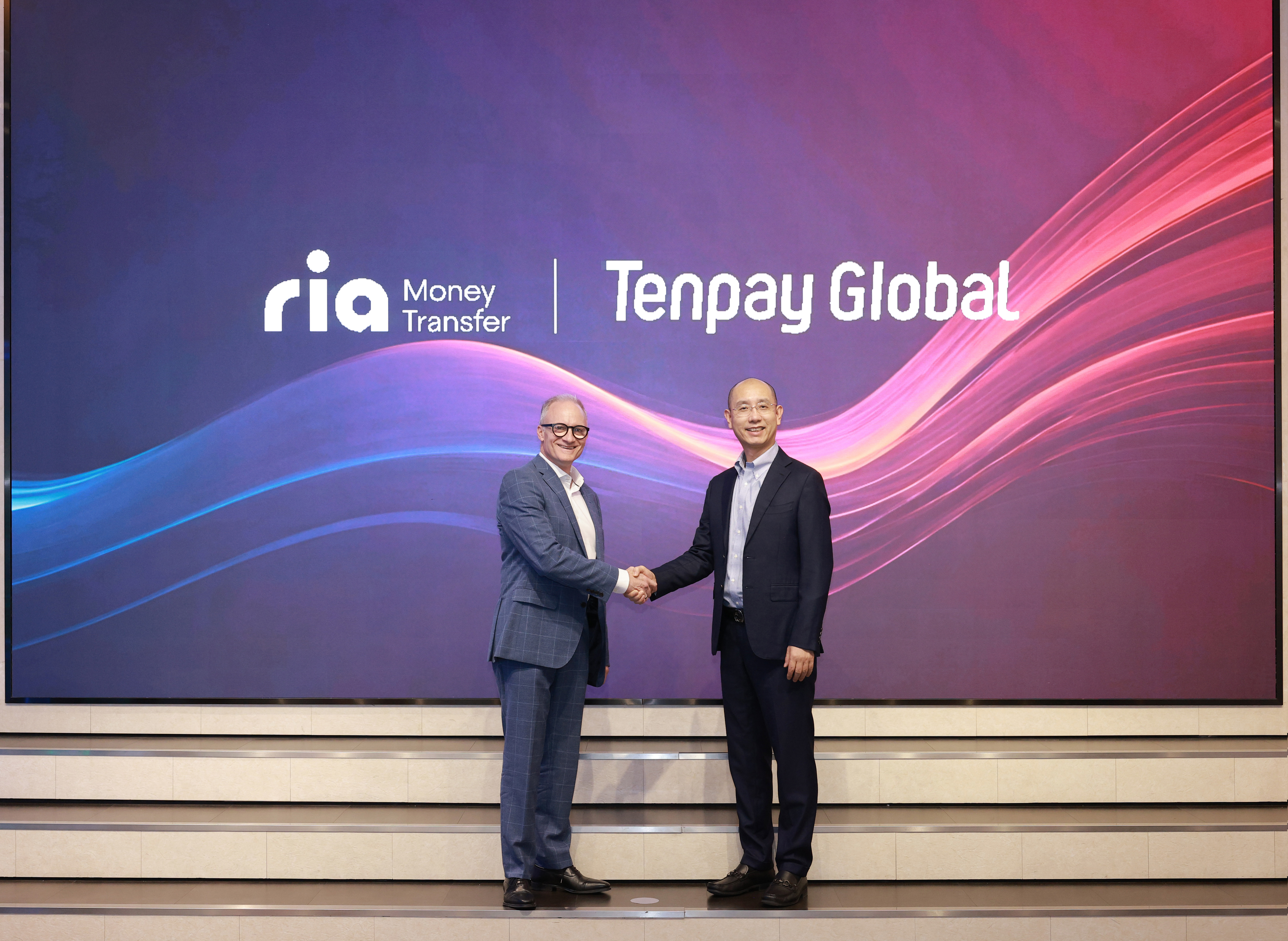 A photo of Shawn Fielder from Ria and Royal Chen from Tencent shaking hands at the signing ceremony.