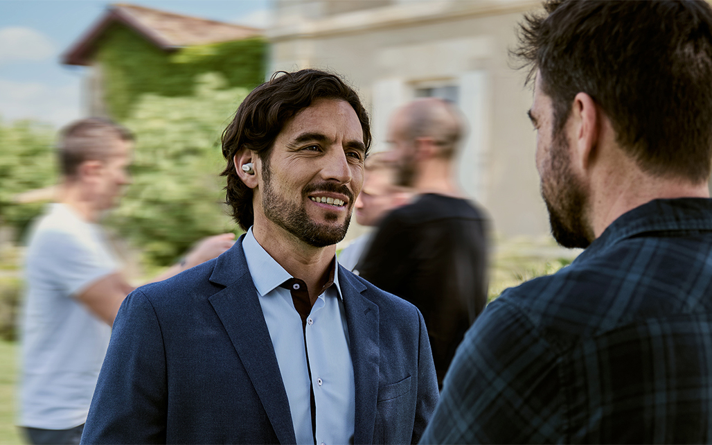 A man using the Cearvol Wave Lite to converse with another person