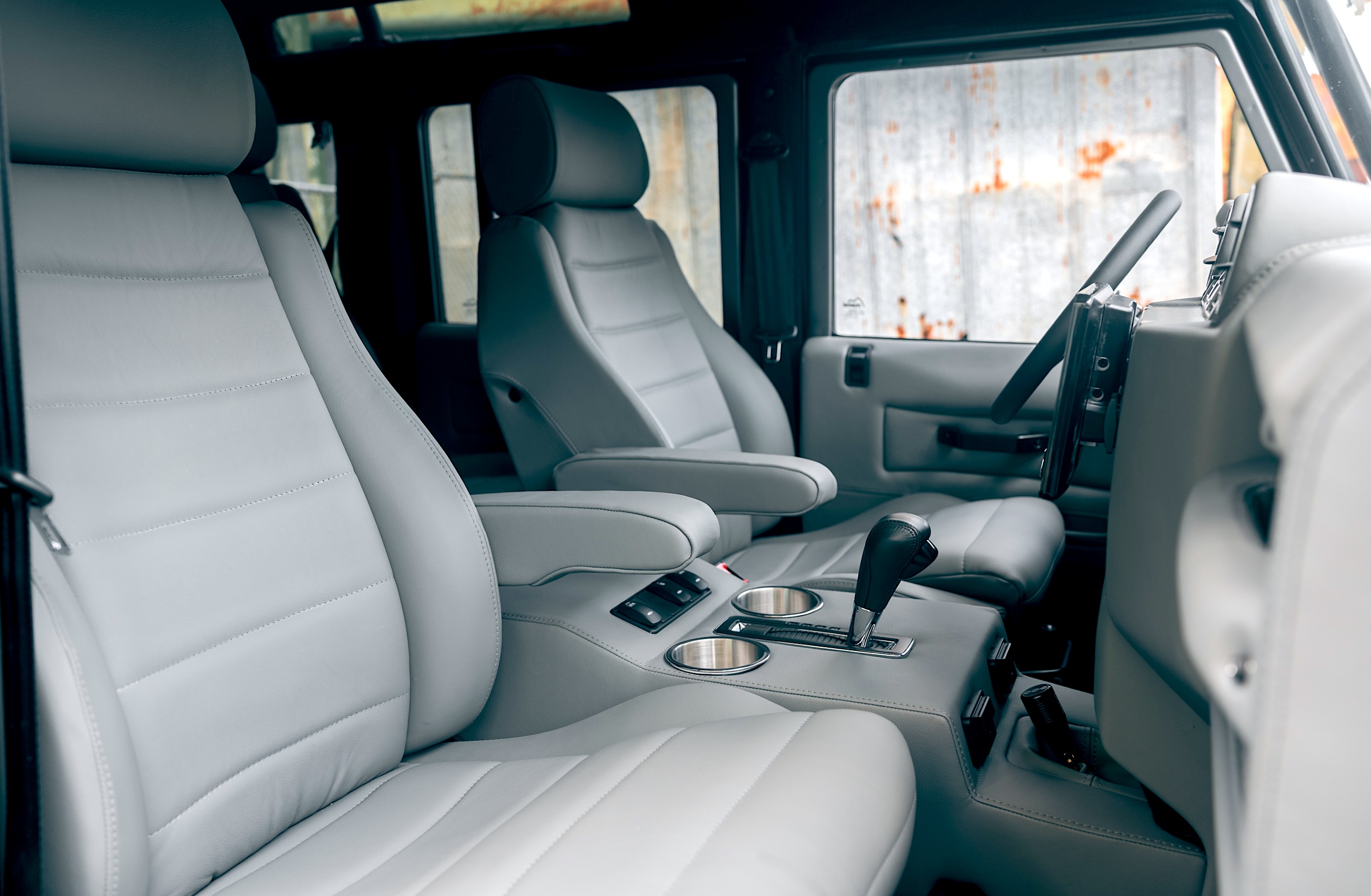 Close-up of custom Scheel-Mann seats inside a restored ECD Defender, showing luxury upholstery, center console, and ergonomic upgrades.