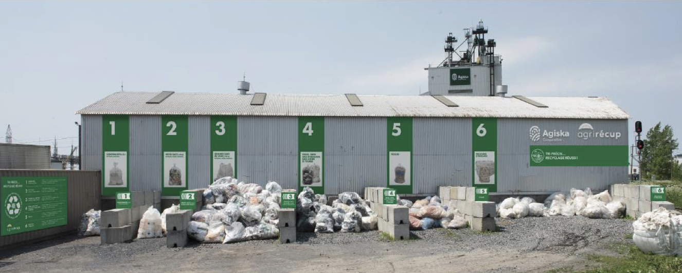 Un plan large d'un point de dépôt de plastiques agricoles chez notre partenaire Agiska Coopérative à Saint-Hyacinthe, Québec. On y voit des sacs de fi