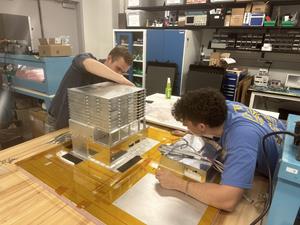 Naval Research Enterprise Internship Program (NREIP) interns from summer 2023 – Wilder Crosier (left) and Tommy Caligiure (right) – helping to assemble the full ComPair instrument in the lab at NASA’s Goddard Space Flight Center, Greenbelt, Maryland.
