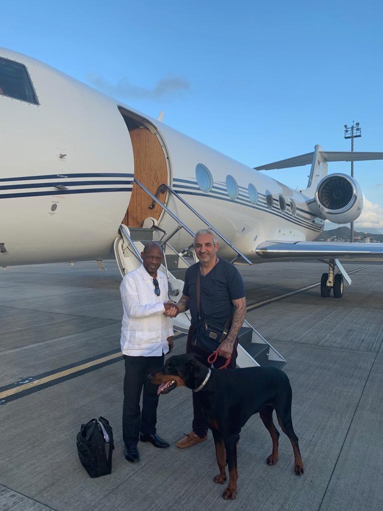 Alki David, CEO of Swissx, with former St. Kitts-Nevis Prime Minister Denzil Douglas (left), who is on the board of the Swissx Bank of Cannabis. Pictured with the Swissx Express jet and Vader, David's Doberman who is the subject of a Swissx Genetics breakthrough cloning project. 