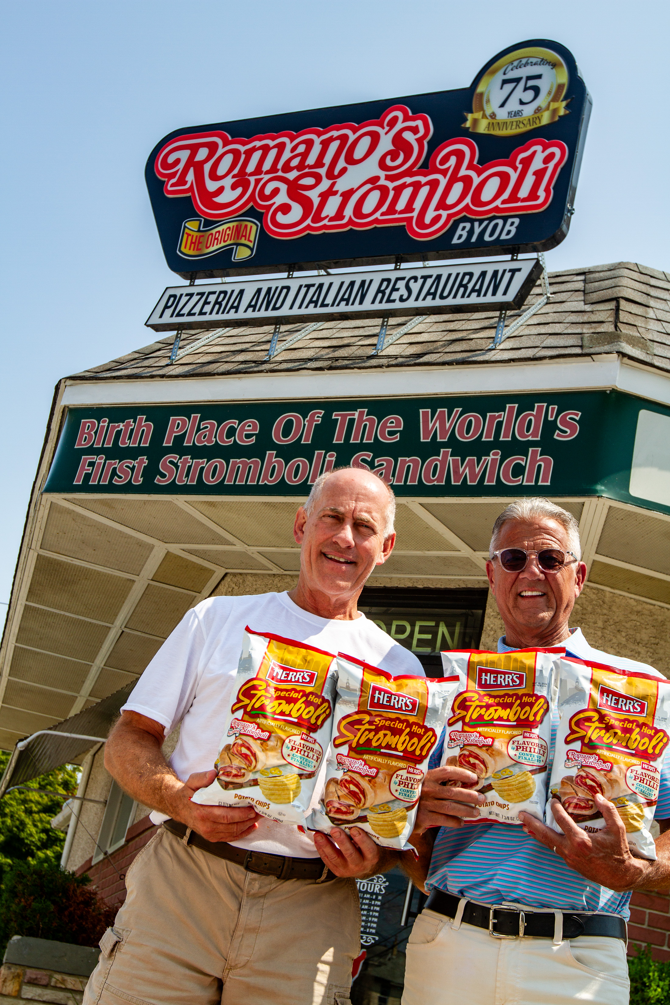 Ed Herr, Chairman and CEO of Herr's, celebrates the winning flavor of the 2024 "Flavored by Philly" contest, Special Hot Stromboli chips, alongside Peter Romano, owner of Romano’s Stromboli.