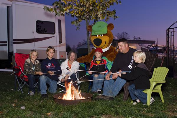 Family and Yogi at campfire and RV