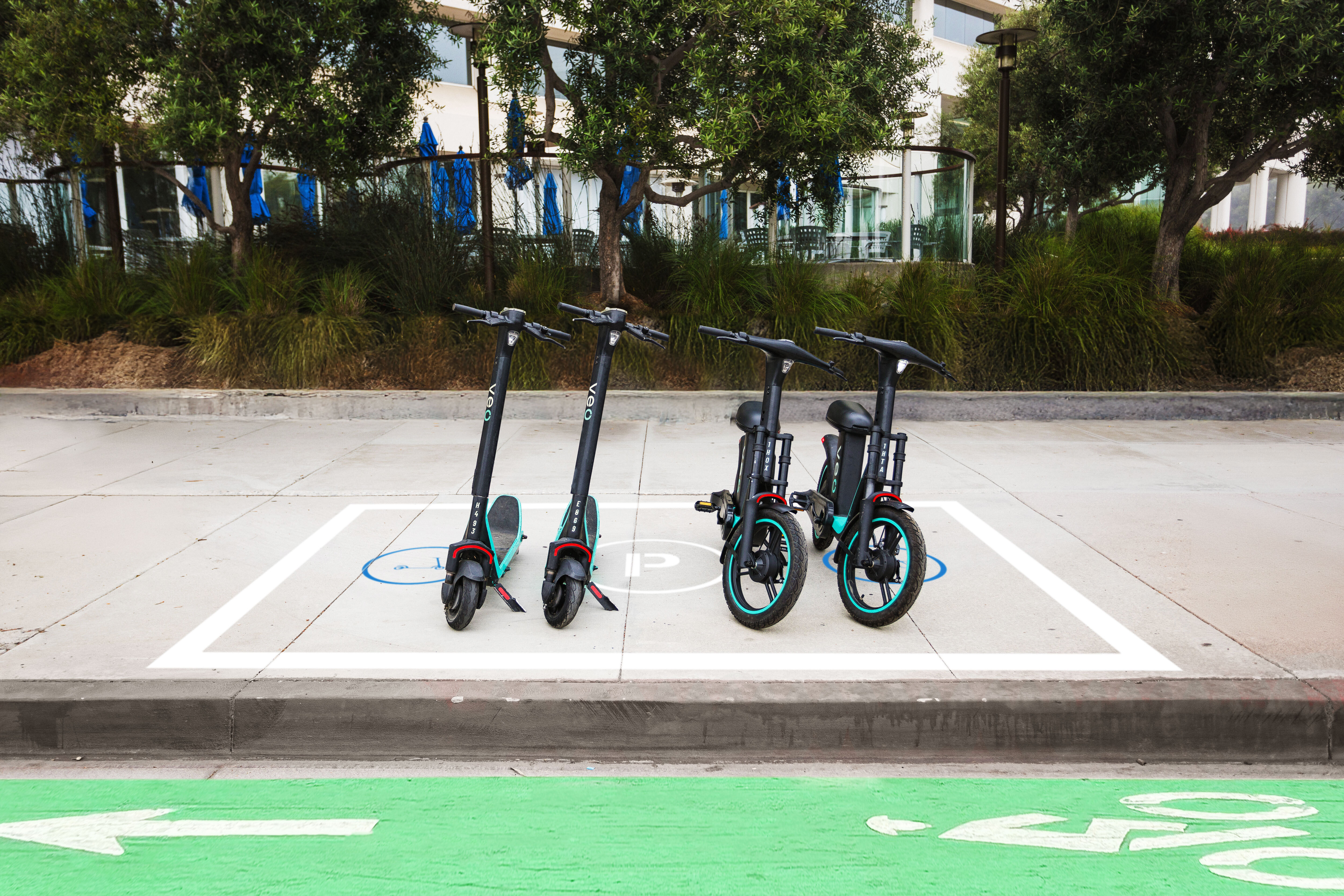 Veo's standing scooters and seated vehicles parked neatly in a designated corral, showcasing how Captur's AI technology helps ensure responsible parking.