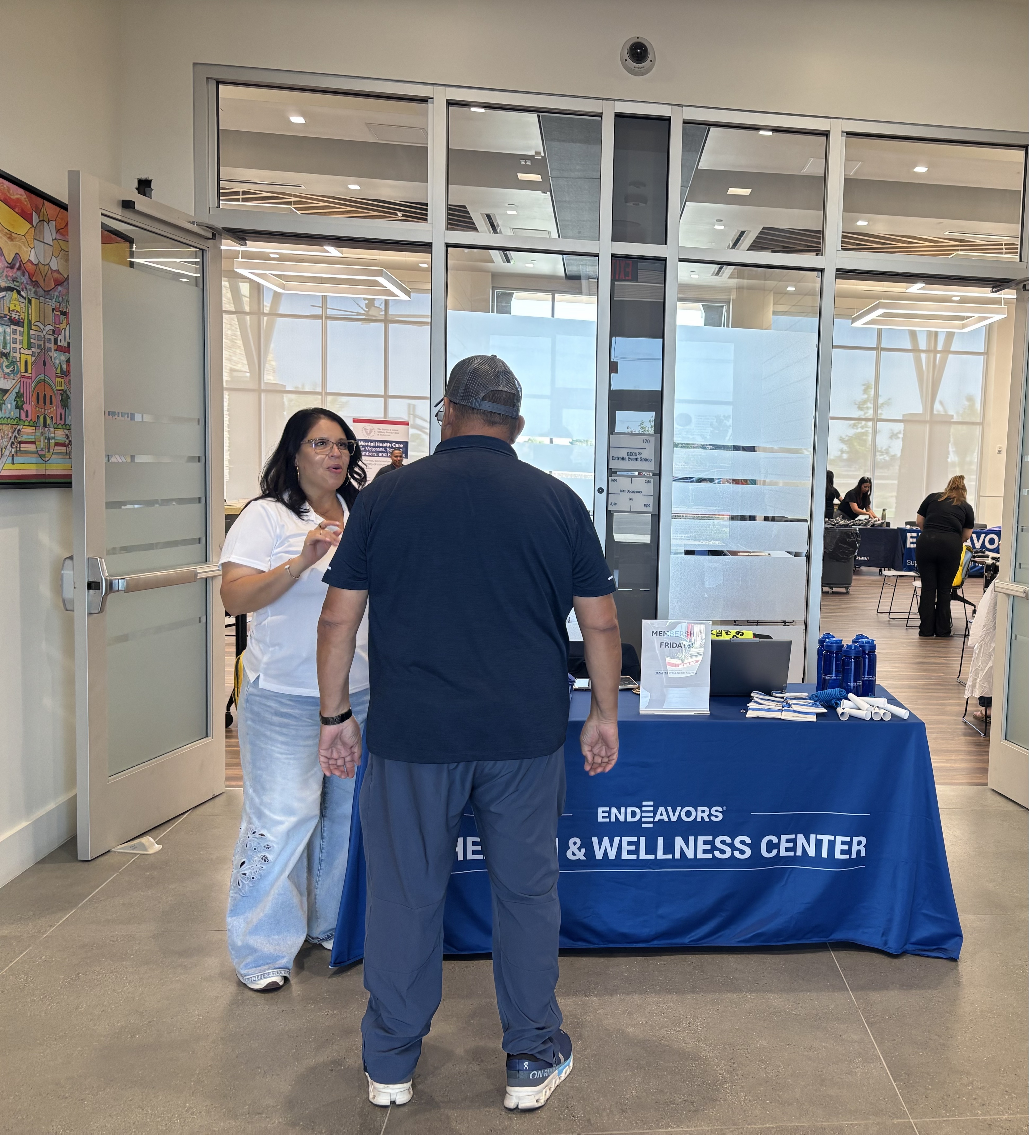 Endeavors staffer welcomes attendee to Haircuts for Heroes event