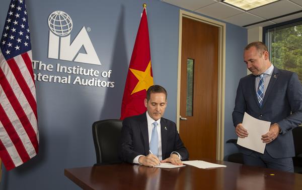 IIA President and CEO Anthony J. Pugliese signs MOU with IIA Director of Strategic Global Initiatives Greg van Choyke.