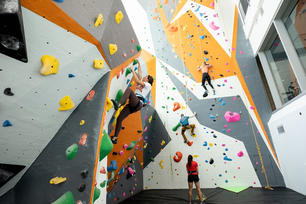 Syracuse Univesity students climb on the 48-foot-tall climbing wall located in the newly-opened Barnes Center at the Arch. This state-of-the-art health, wellness and recreation complex features services in one central and convenient location. Those services include the Counseling Center, Health Promotion Office, health clinics, pharmacy, and recreation services. 