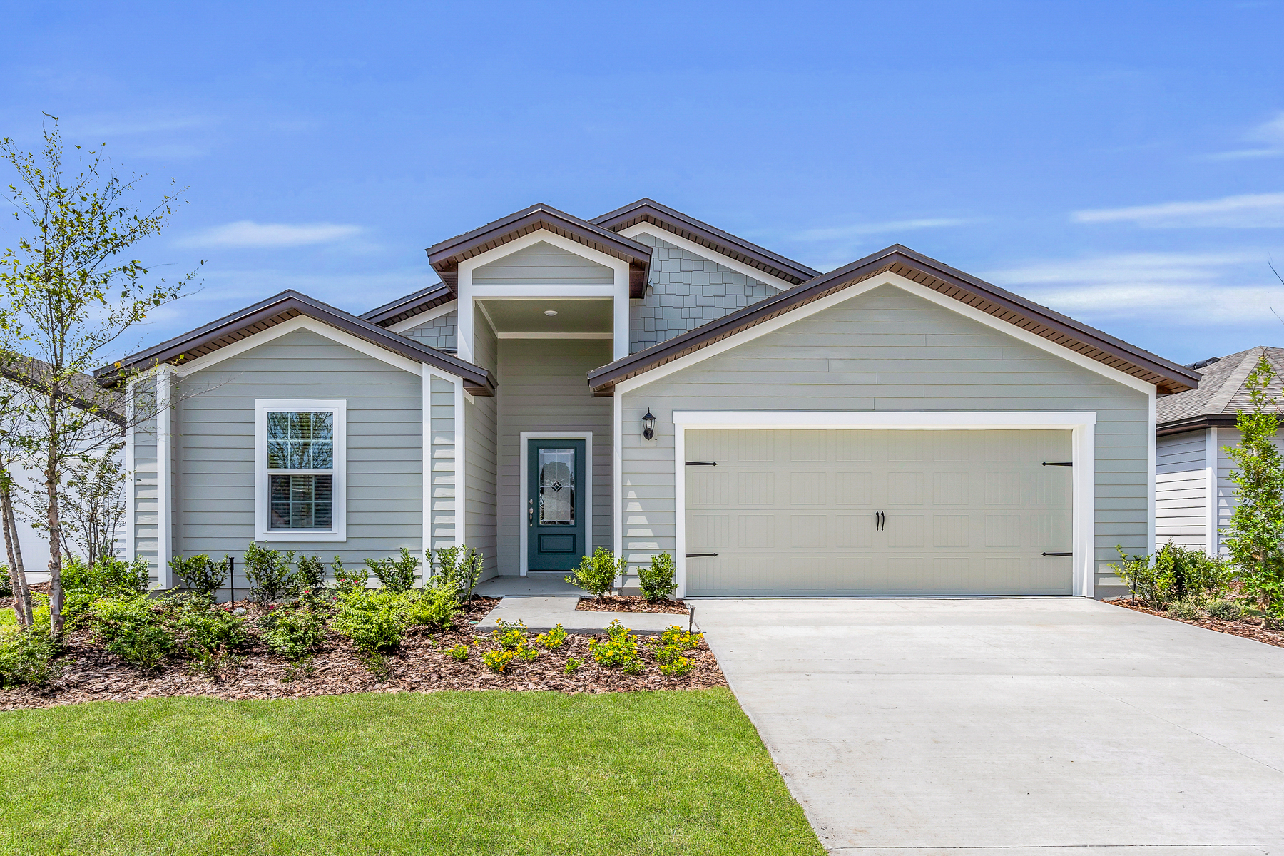 The Hillcrest plan at Whisper Ridge includes a stately exterior with a tall covered porch and professional front yard landscaping. 