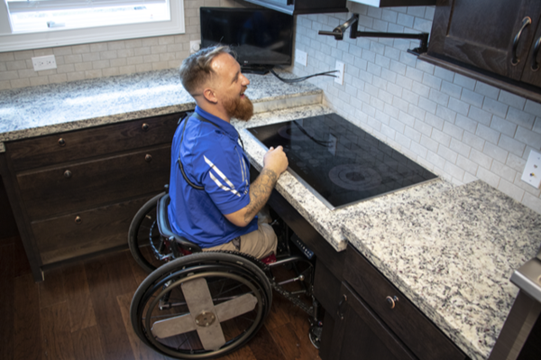 U.S. Army SPC Terence ‘Bo’ Jones operating his new stove that raises and lowers to wheelchair height. 