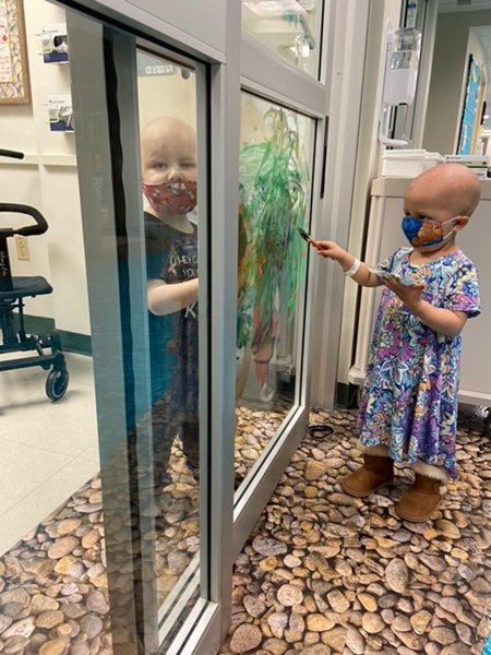 Four-year-old Eli Feliciano and 3-year-old Liliana Dietrich paint safely together in a chemotherapy infusion center at Children's Hospital of The King's Daughters in Norfolk, Va.
Photo courtesy: CHKD