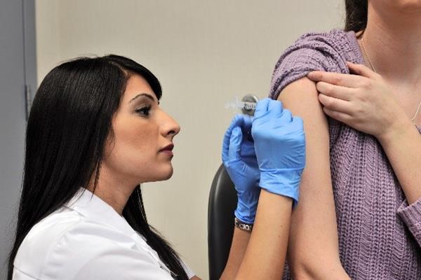 A pharmacist at London Drugs administers a flu shot