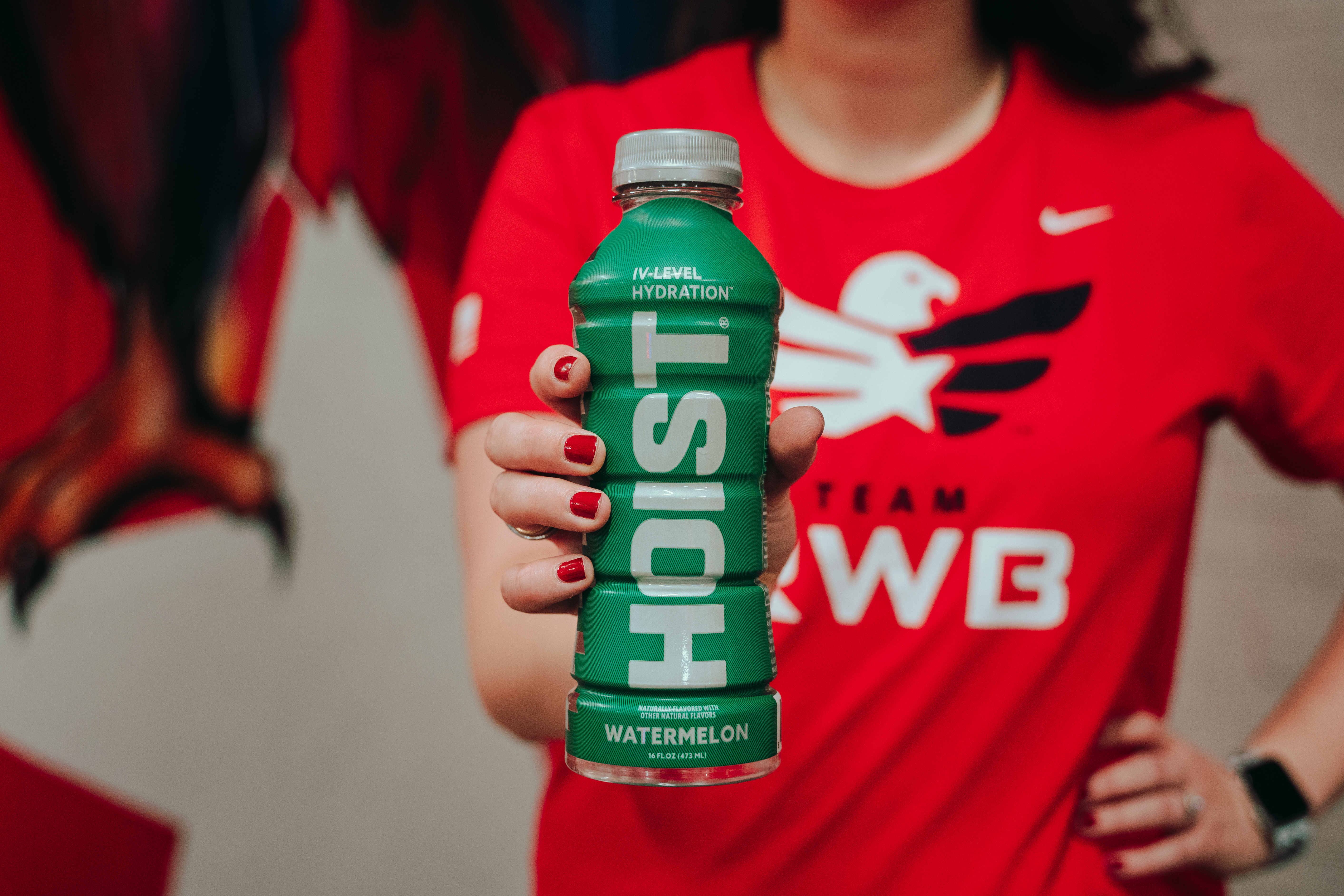 A Team Red, White & Blue member holds a bottle of HOIST