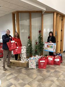 TopLine employees and Non-Profit partner stand with donations