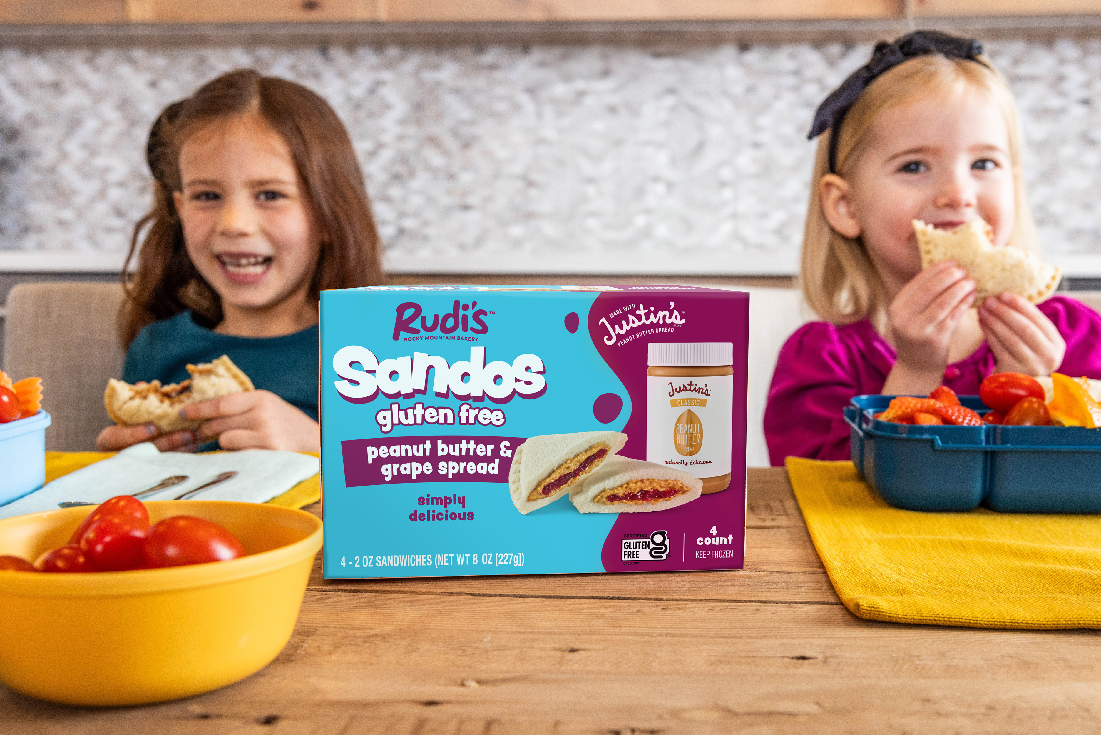 Two young girls eating new gluten free Sandos from Rudi's at a counter top