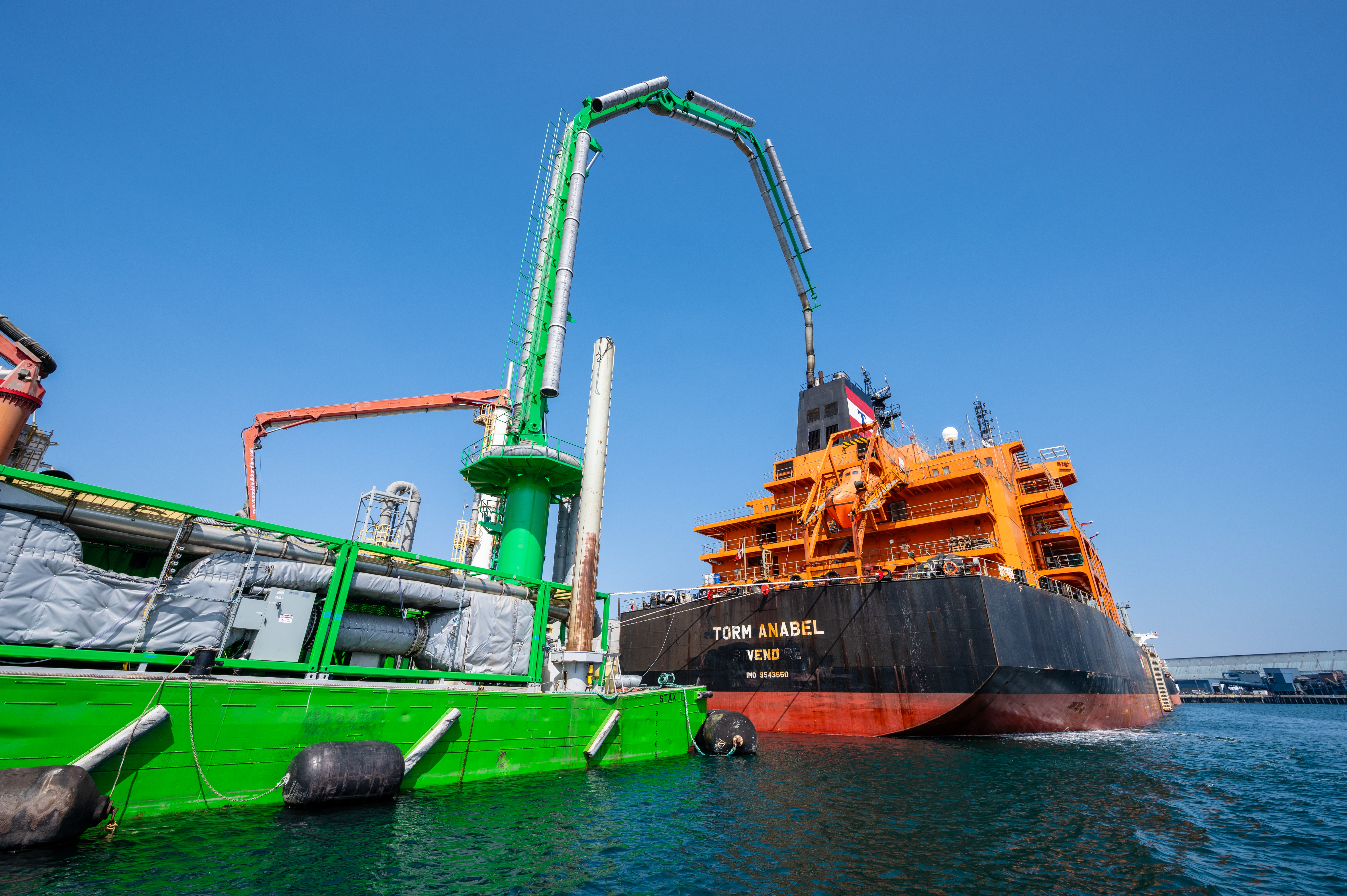 A STAX emissions-control system operates alongside a tanker in port, capturing exhaust directly from the vessel while it remains docked.