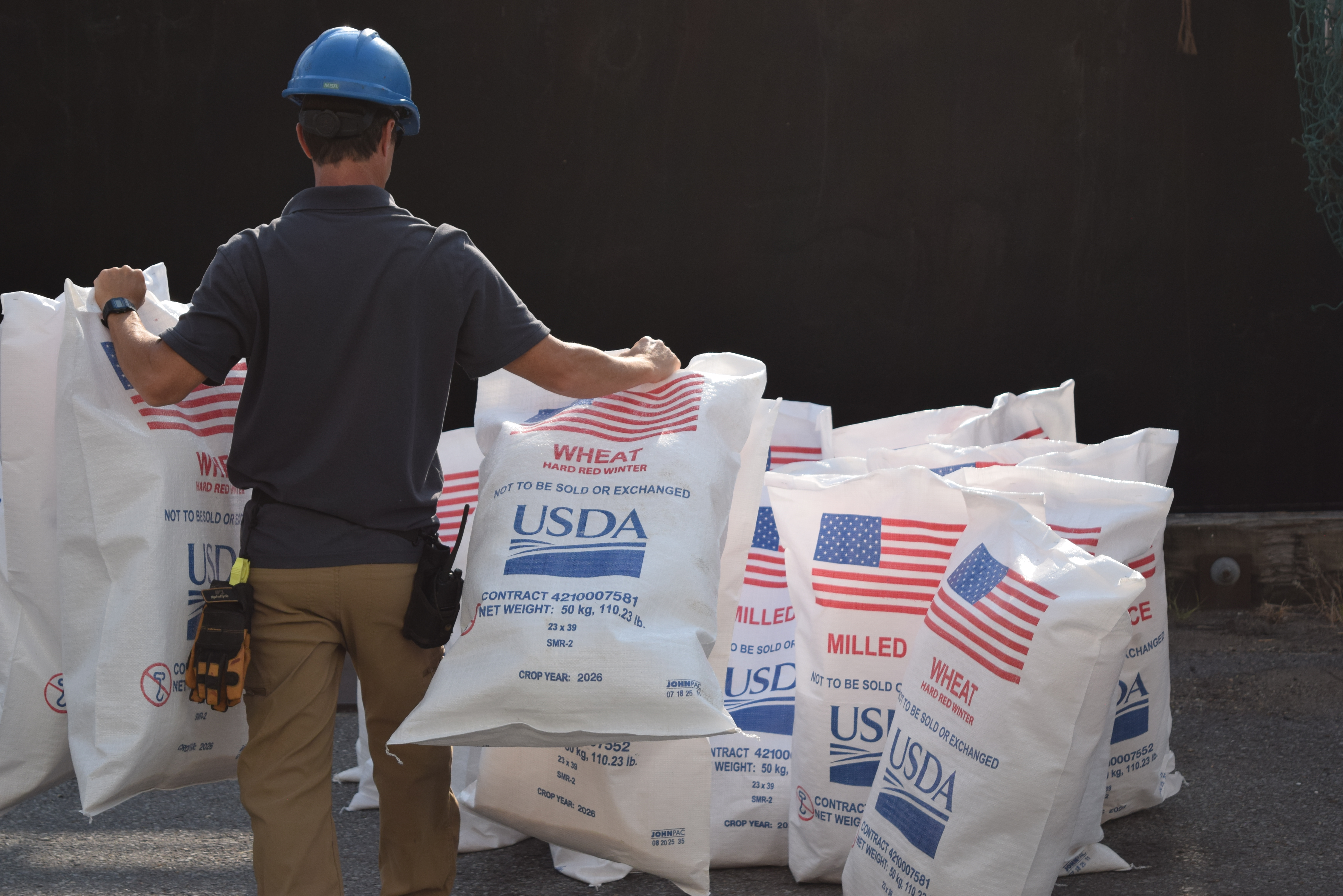 A mariner sets down bags of cargo destined for Kenya