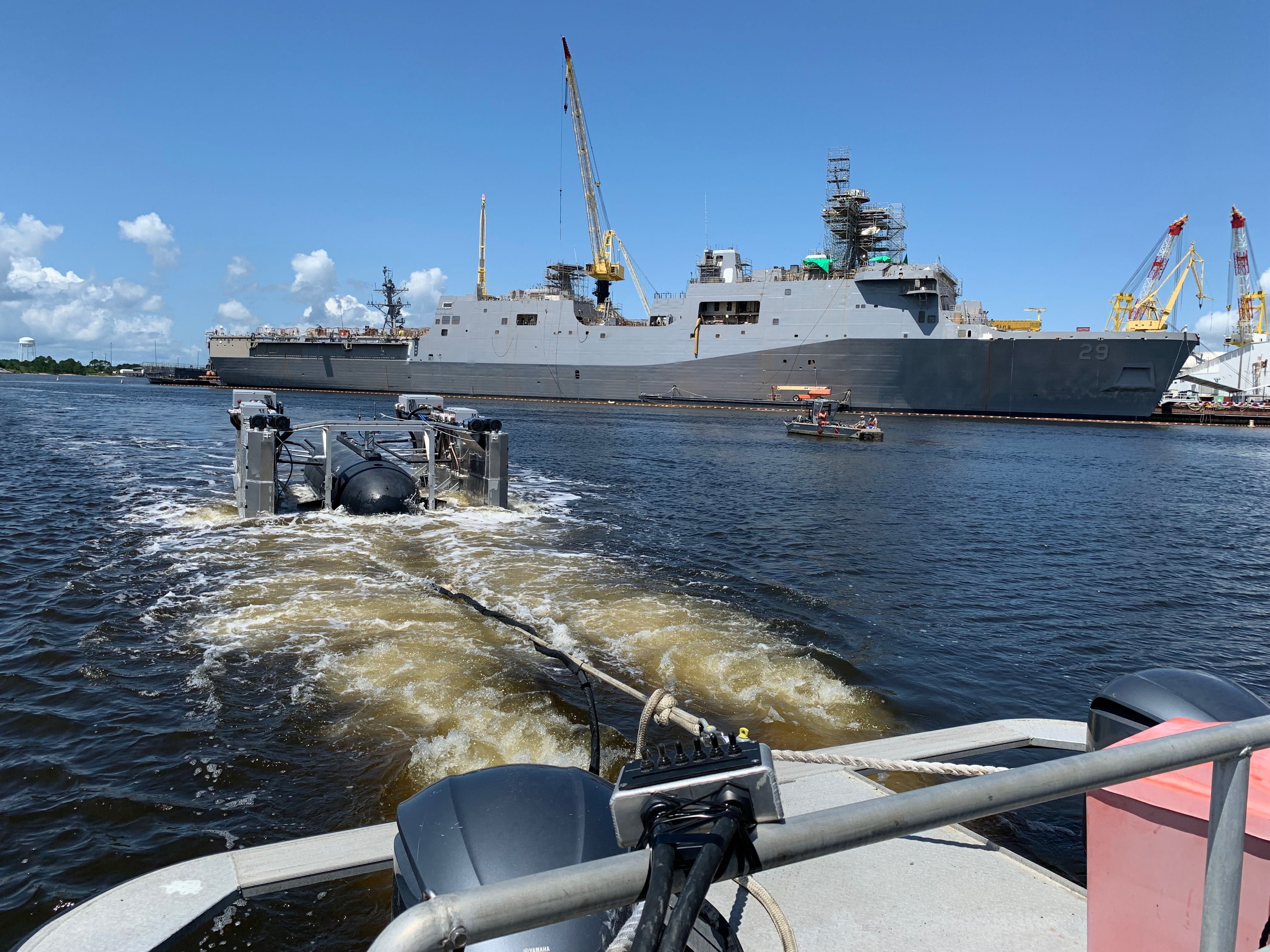 HII’s Pharos prototype platform being towed behind a small craft in the Pascagoula River while recovering HII’s Proteus LDUUV during a demonstration June 8, 2022.