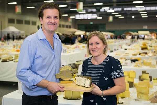 Angélique Hollister, executive director of the USA Cheese Guild with John Farrand, managing director of the Guild of Fine Food, organizer of the World Cheese Awards, holding the 2019 WCA World Champion Cheese, Rogue River Blue from Rogue Creamery, OR which also won the Best USA Cow’s Milk Cheese trophy (sponsored by the Guild).  