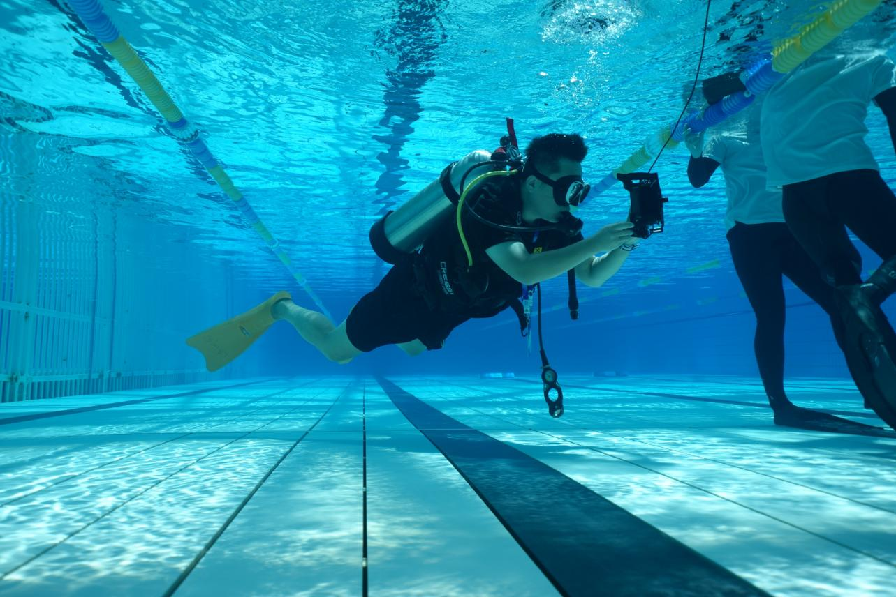 Camera operator following a freediving lane underwater with a smartphone in a DIVEVOLK housing