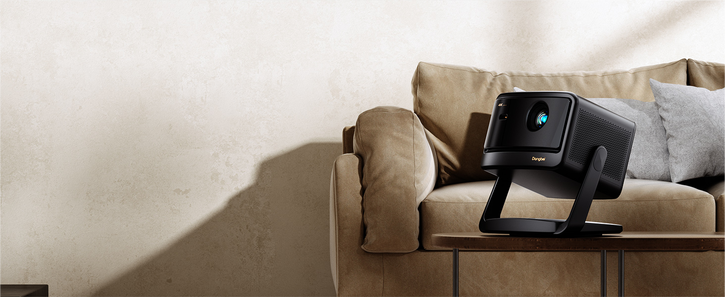 Dangbei DBOX02 Pro 4K laser projector with gimbal stand on a side table next to a living-room sofa.