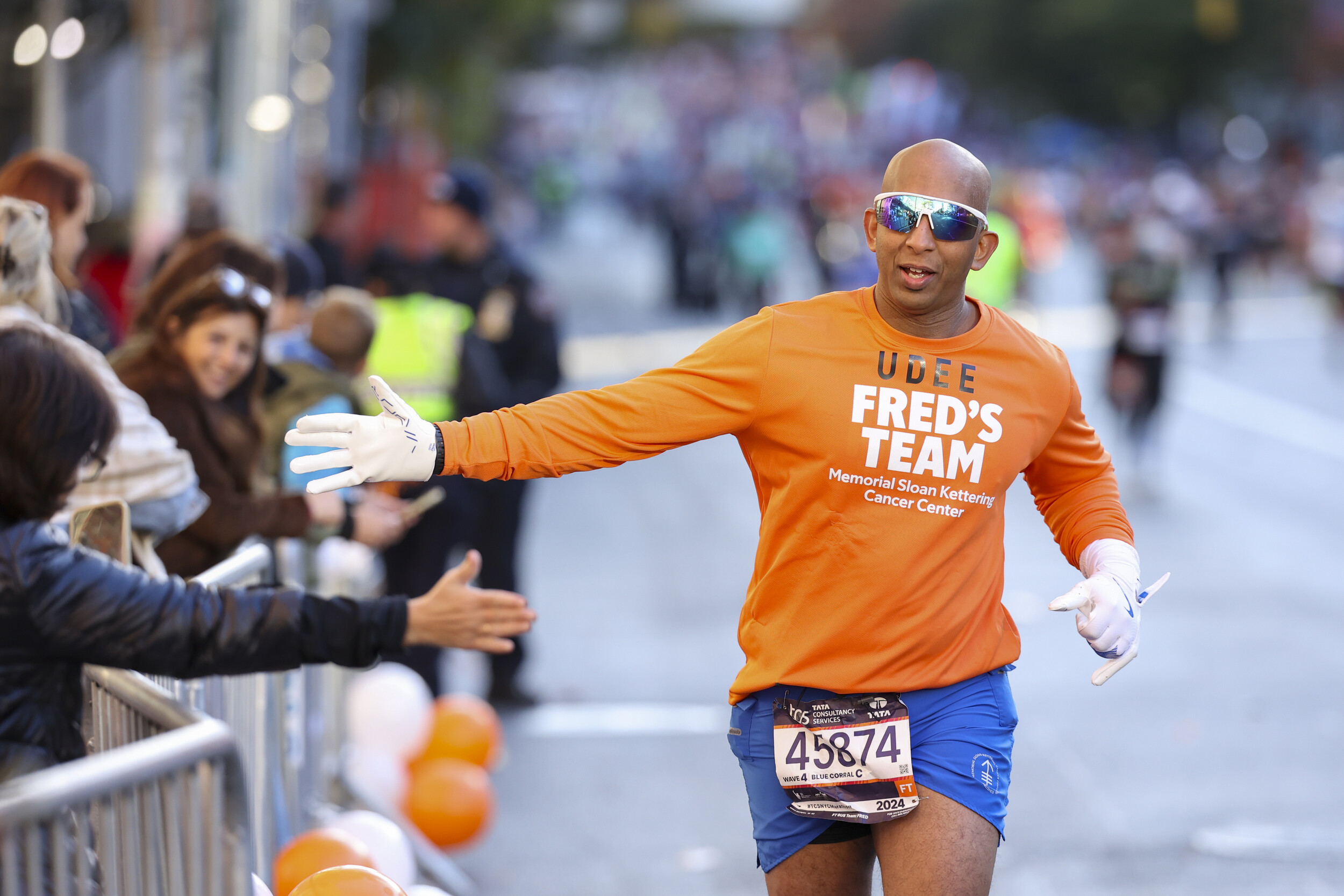 A Fred's Team runner greets supporters during the 2024 TCS New York City Marathon. 100% of the money raised through Fred's Team goes directly to cancer research at Memorial Sloan Kettering Cancer Center. (Photo by Shea Kastriner for Fred's Team)