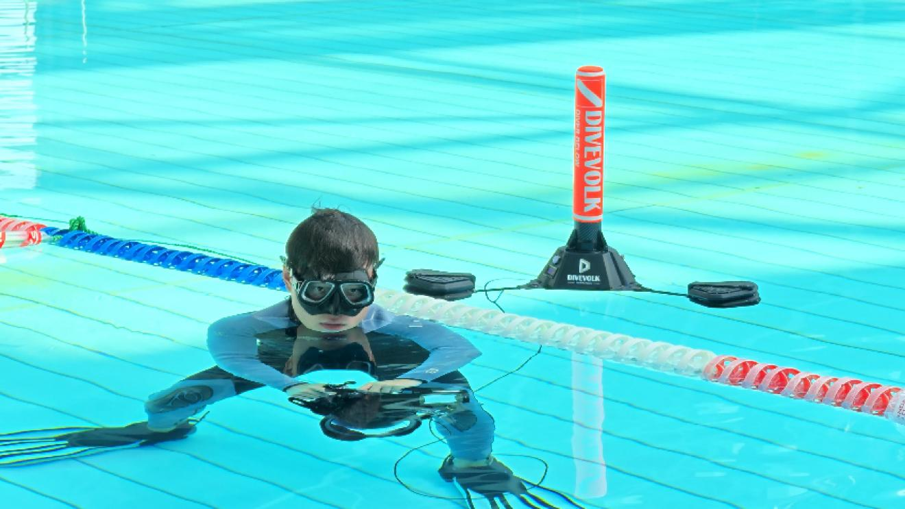 Freediver at the surface of the competition pool beside a DIVEVOLK SeaLink surface buoy