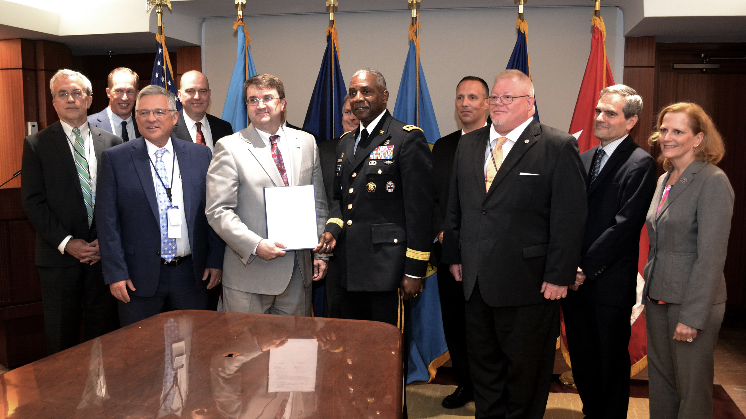 Department of Veterans Affairs Secretary Robert Wilkie (center left) and Defense Logistics Agency Director Army Lt. Gen. Darrell Williams (center right) display the newly signed interagency agreement between DLA and VA with the team who helped make it possible behind them at VA Headquarters in Washington, D.C., Aug. 12.