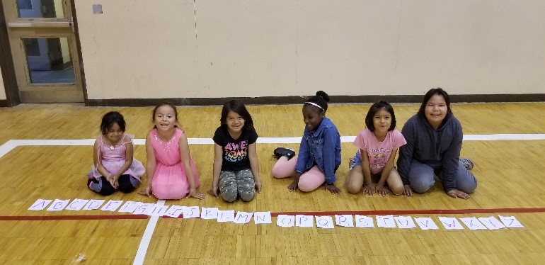 Campers in Fort Albany First Nation play a word game and collect all letters of the alphabet during Summer Literacy Camp.