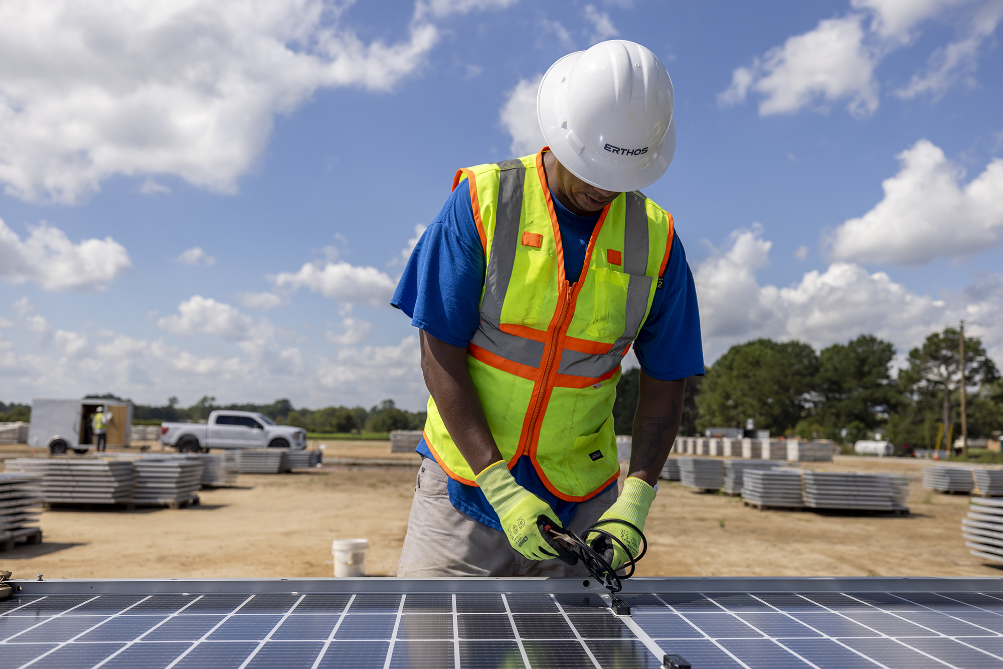 A worker prepares a solar module for installation on an Earth Mount Solar project.