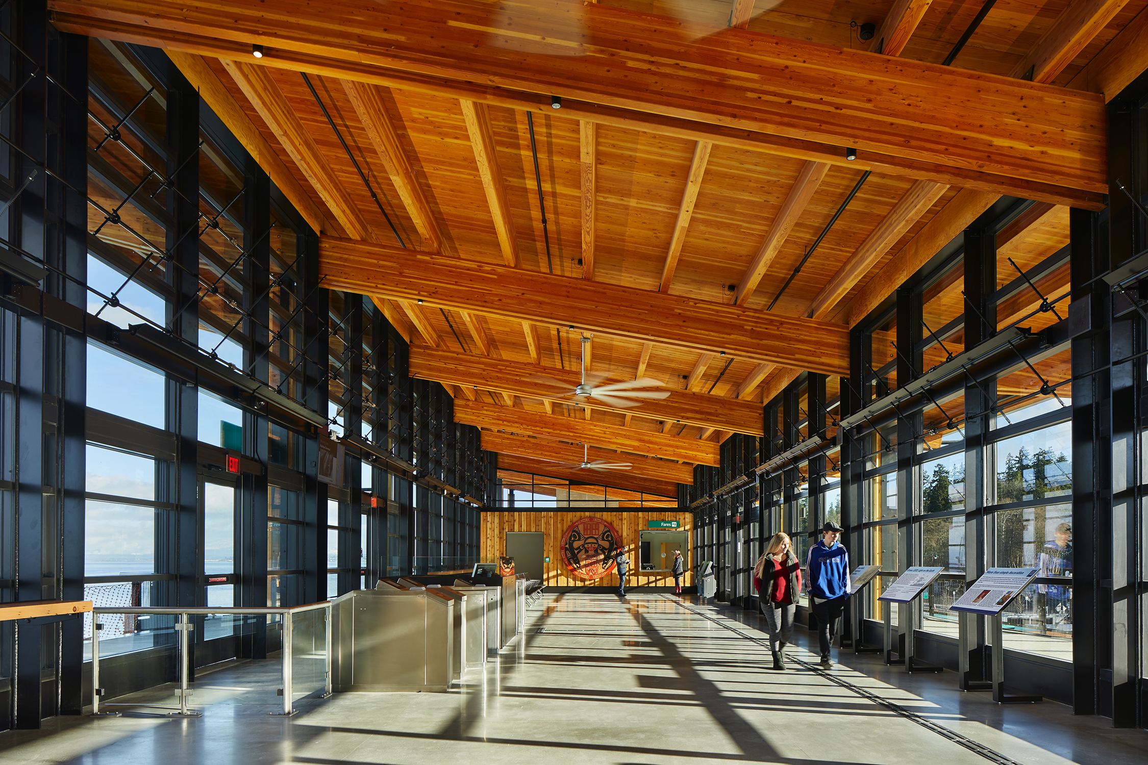 Interior of the Mukilteo Multimodal Ferry Terminal gathering hall with views of the water. The waiting room is a daylight-filled space with views to land and sea that help orient ferry riders. Photo: © Benjamin Benschneider.