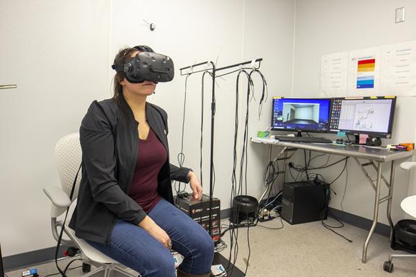 A participant uses virtual technology while LSU researchers monitor her thermal behavior. This is part of a project that aims to increase energy efficiency in building design through the use of immersive virtual environment technology.