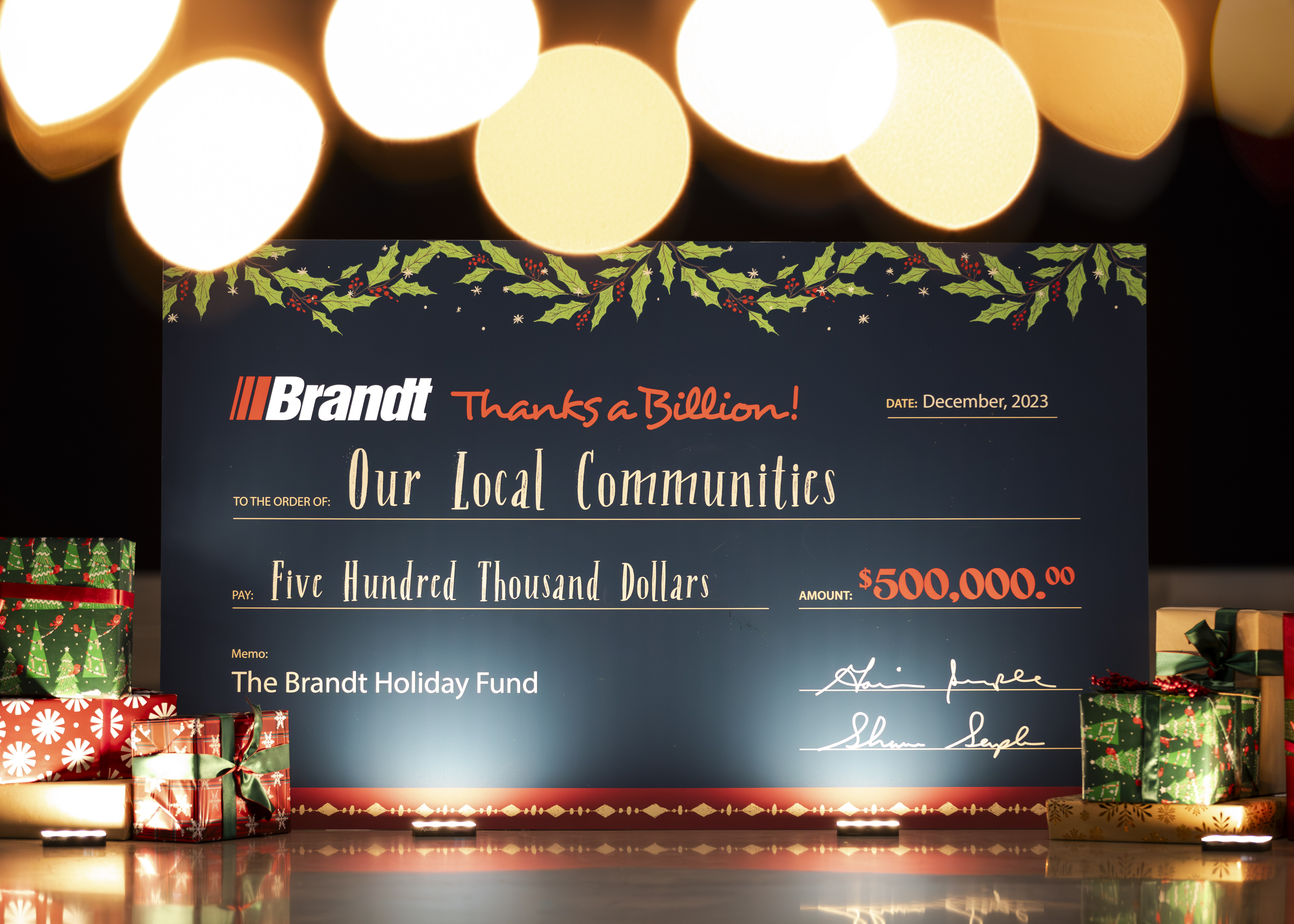 A photo of a cheque showing the total donation of $500,000 to local charities.