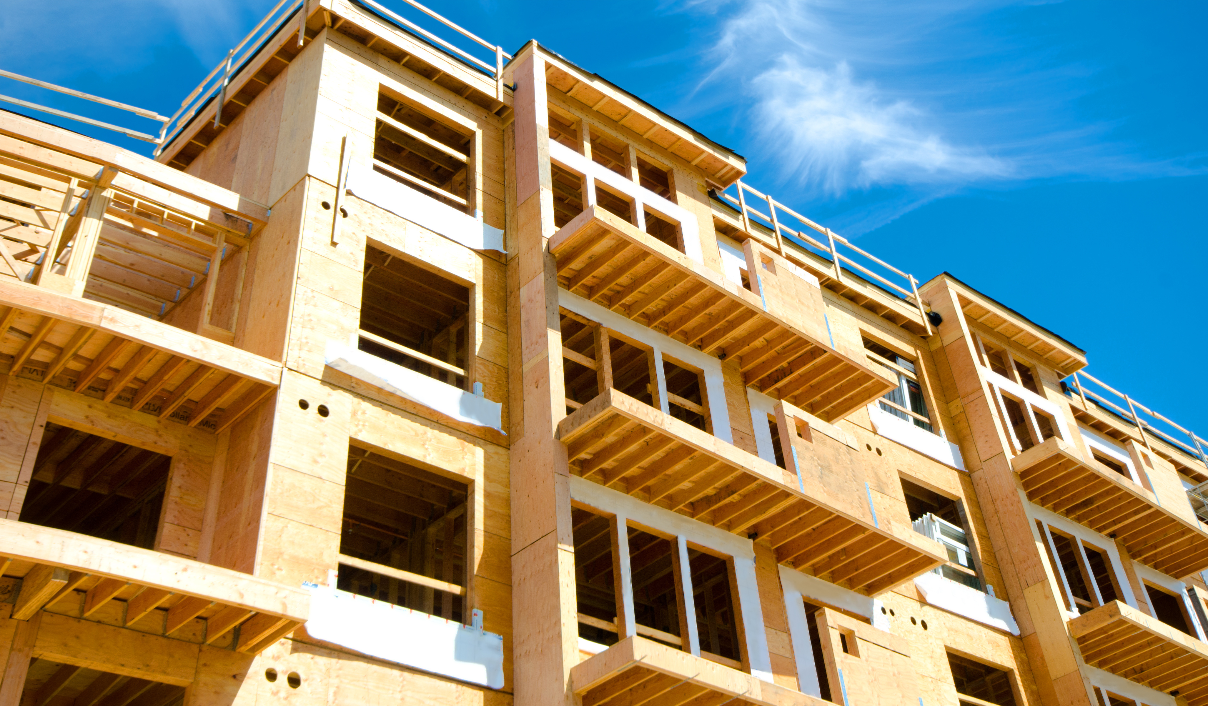 A multi-story apartment building under construction representing the development of affordable housing projects financed 