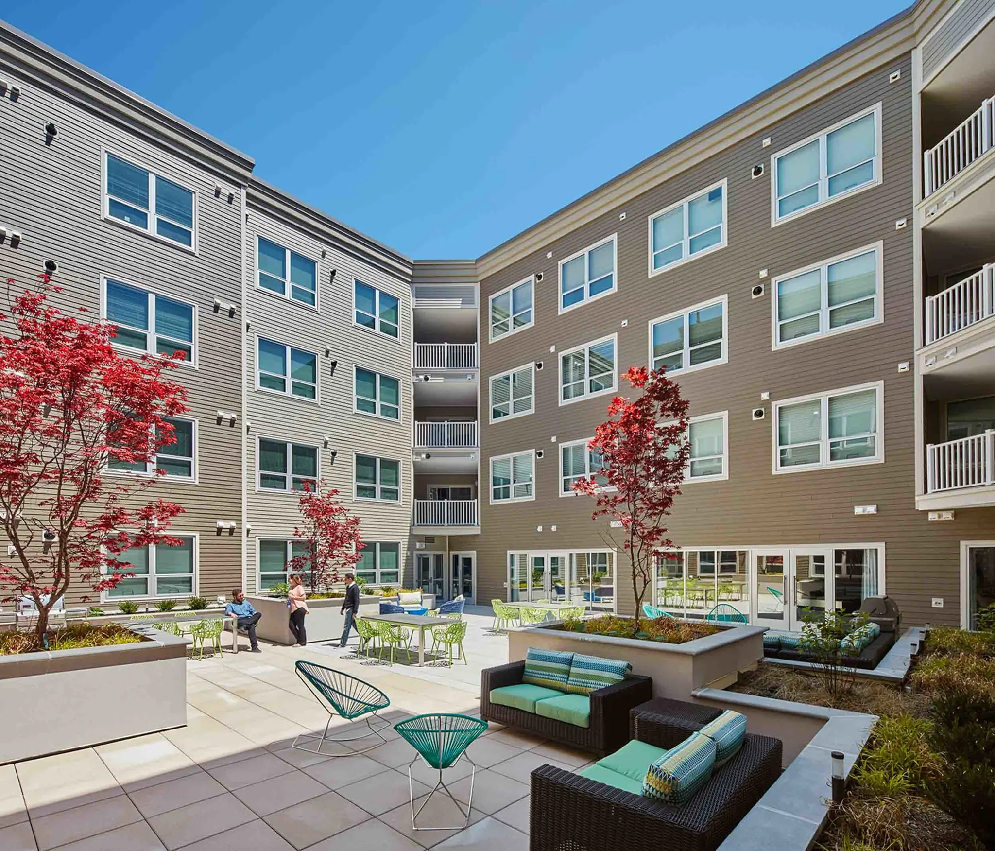 Outdoor courtyard at College & Crown featuring landscaped seating areas and open-air space.