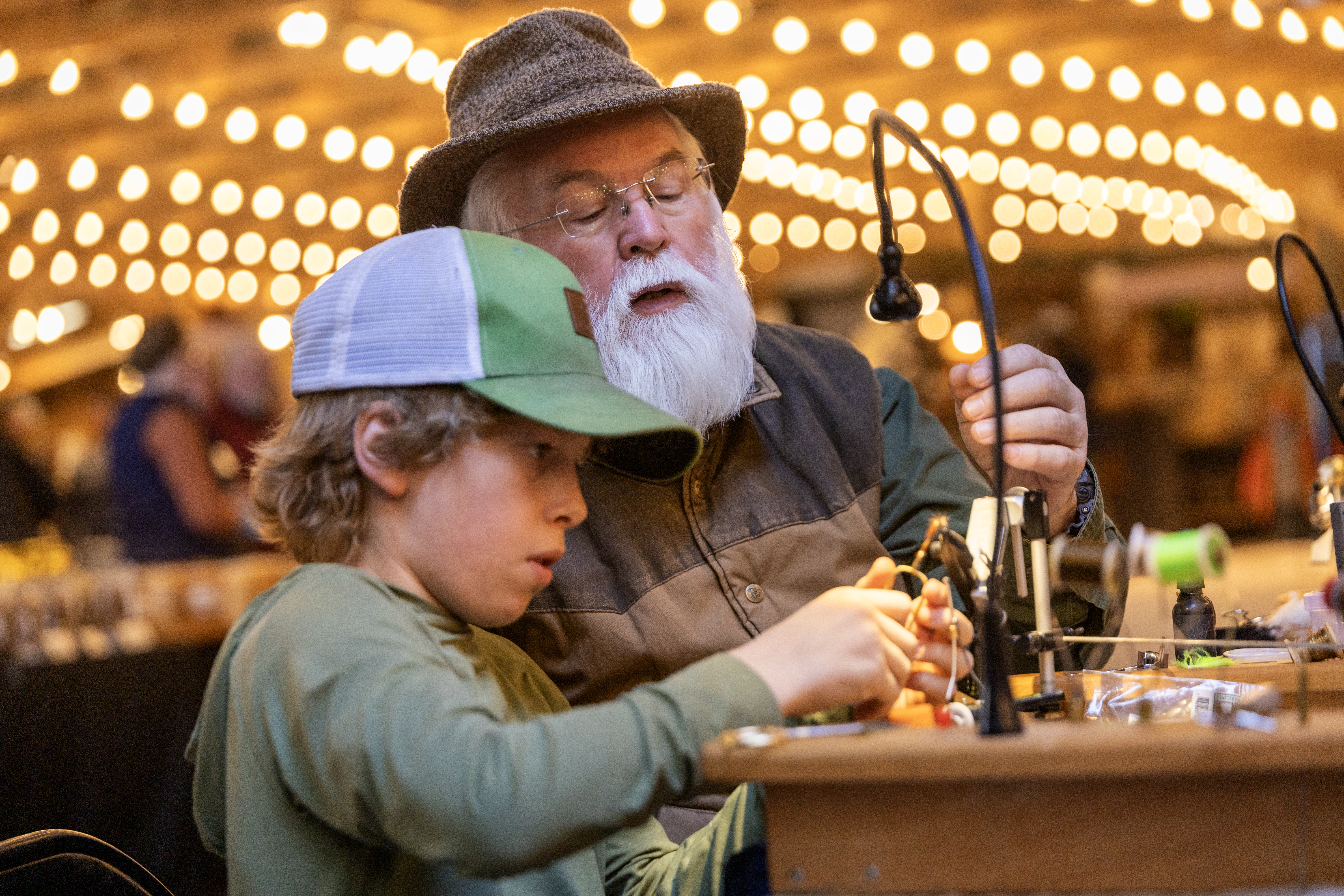 Tackle maker and boy making brass fishing lure