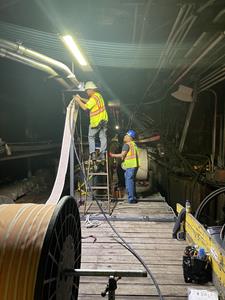 Hylan team members shown installing fiber optic cables in the PATH transit tunnel