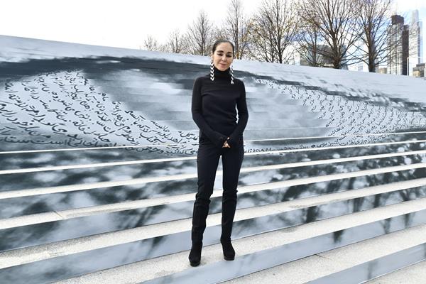 Shirin Neshat poses with her artwork at Eyes on Iran Art Exhibit by Woman Life Freedom