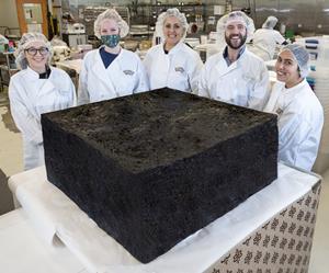 Cannabis company MariMed unveils the World's Largest Cannabis Infused Brownie to celebrate the December 7th, 2021 launch of its Bubby's Baked brand. Pictured left to right are MariMed kitchen confectioners Olivia Jodway, Kim Striar, Michelle Morse, Jake Dean, and Nikole Braga. PHOTO/Jon Simon