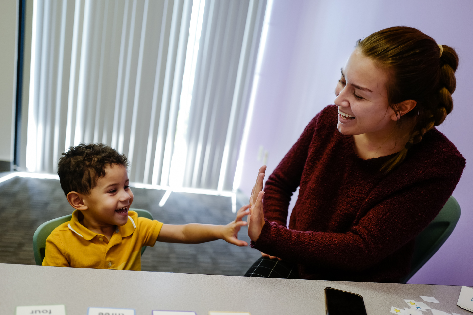 A child works on functional communication with at therapist at InBloom Autism Services.