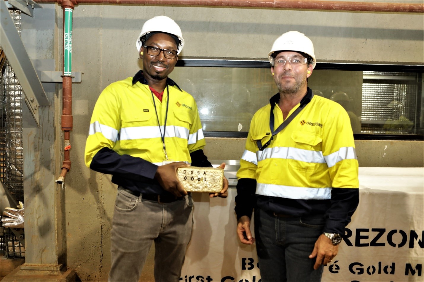 Orezone’s Burkina Faso Country Manager, Ousseni Derra and VP, Project Development, Ricardo Rodrigues holding the first gold doré bar from the Bomboré Mine.