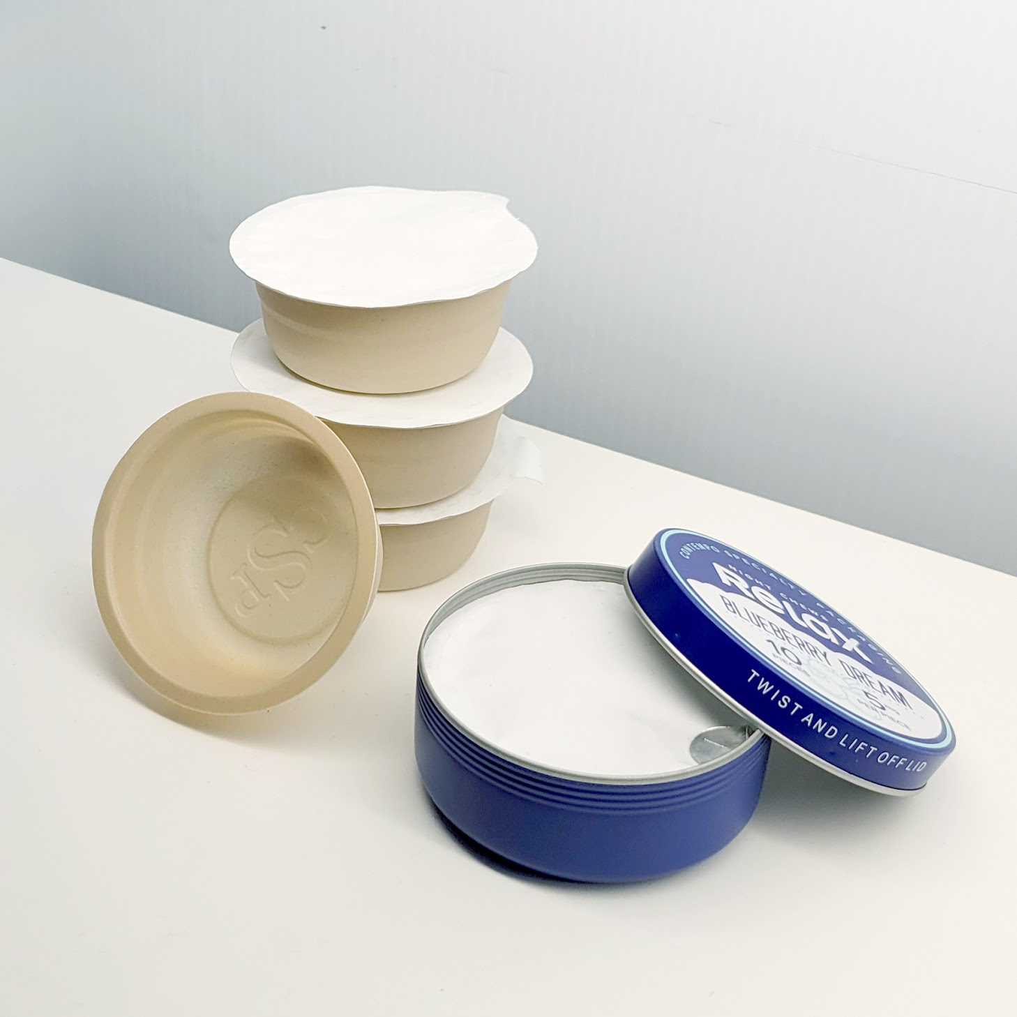 A blue and white tin next to four brown and white tins. 